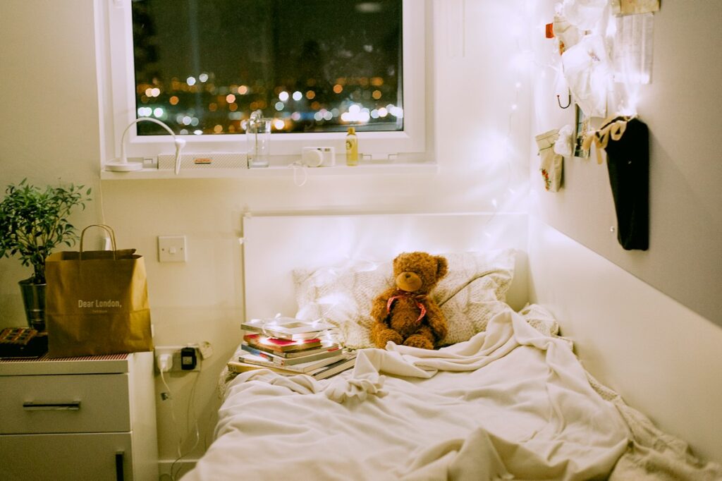 Chambre d’enfant éclairée par une lampe de chevet et une guirlande lumineuse